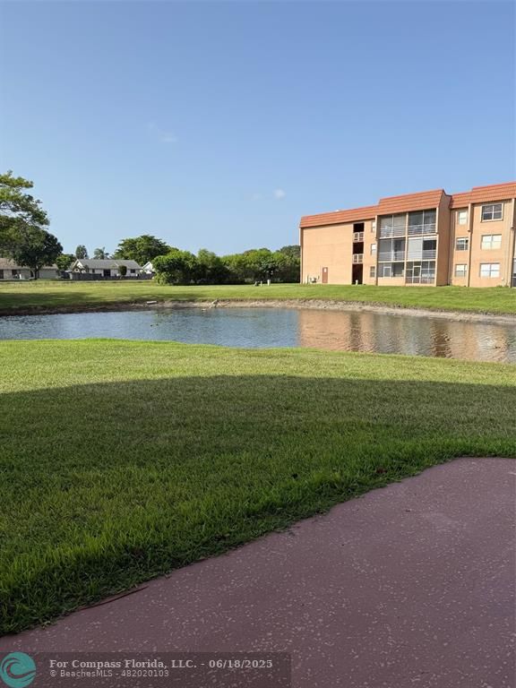 a front view of a house with a yard and lake view