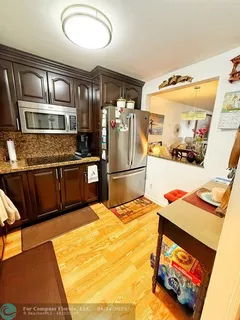 a kitchen with stainless steel appliances kitchen island granite countertop a refrigerator and microwave