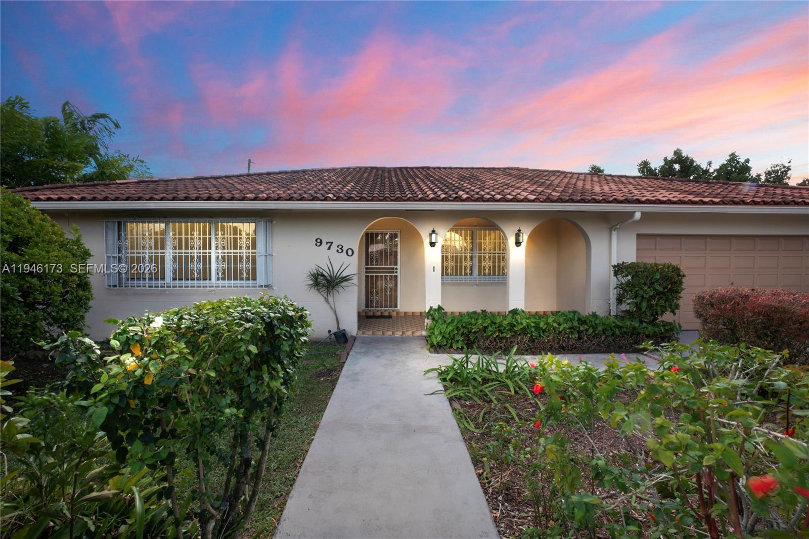9730 Southwest 44th Street Miami, FL 33165 - Photo 2 of 53 a front view of a house with garden