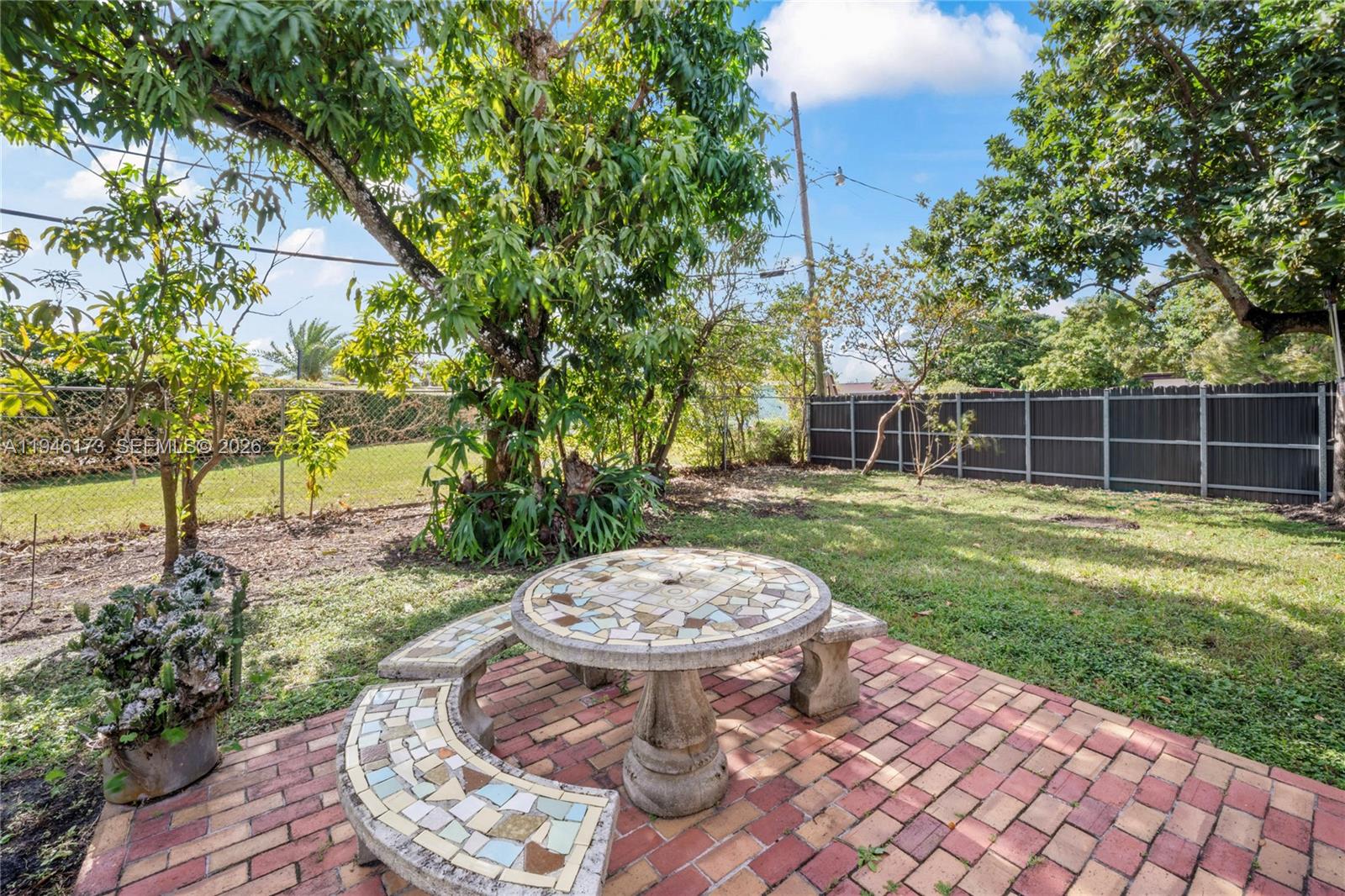 9730 Southwest 44th Street Miami, FL 33165 - Photo 43 of 53 a view of a backyard with a fountain plants and large tree