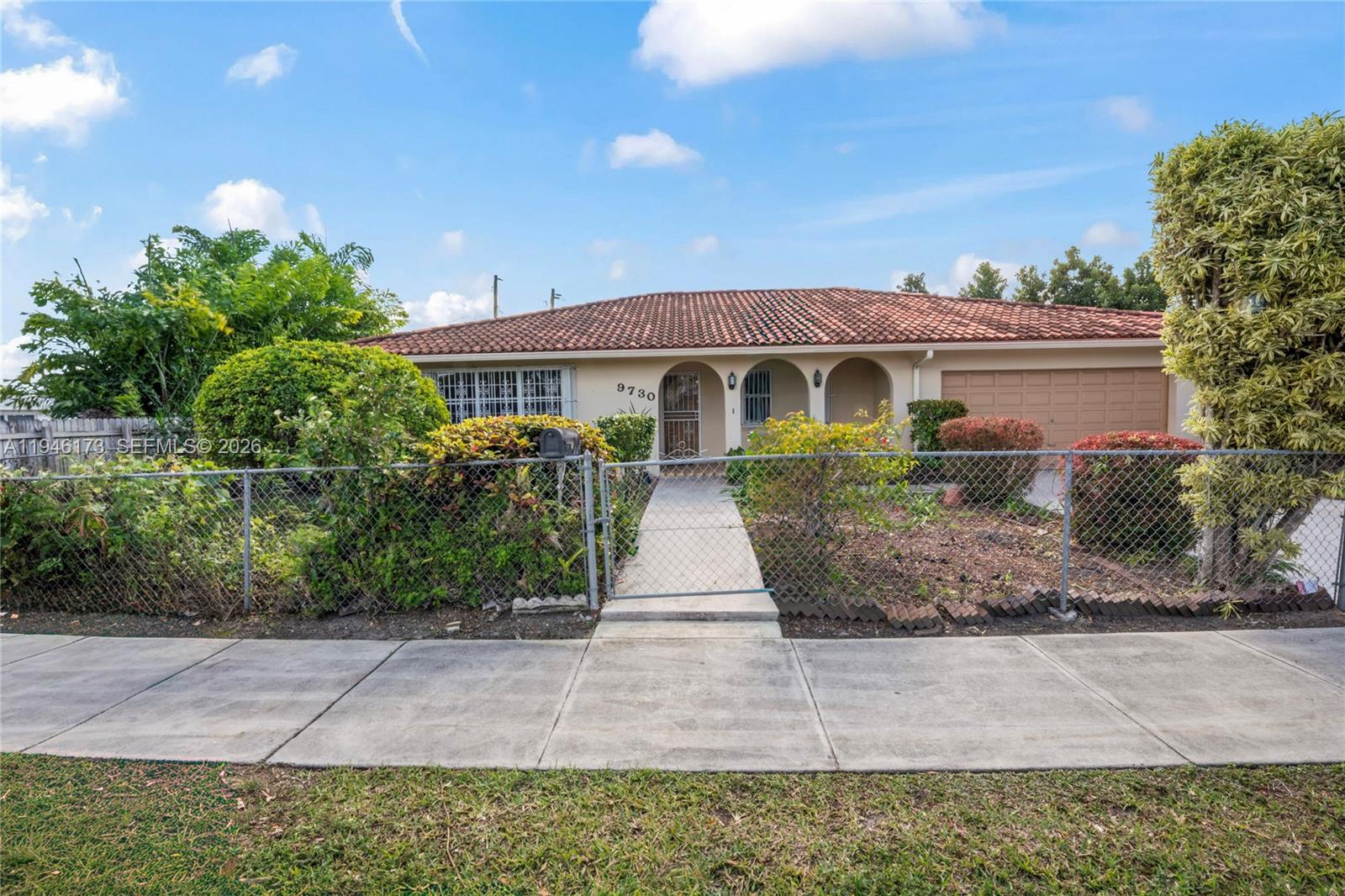 9730 Southwest 44th Street Miami, FL 33165 - Photo 48 of 53 a front view of a house with a yard and potted plants