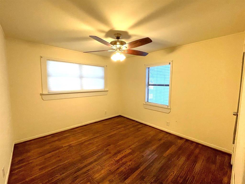 501 South Perry Avenue Denison, TX 75020 - Photo 8 of 11 Room featuring warm wood-finish flooring, light-colored walls, and a ceiling fan with integrated lighting