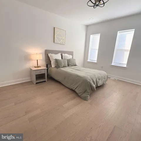 a spacious bedroom with a bed and a lamp