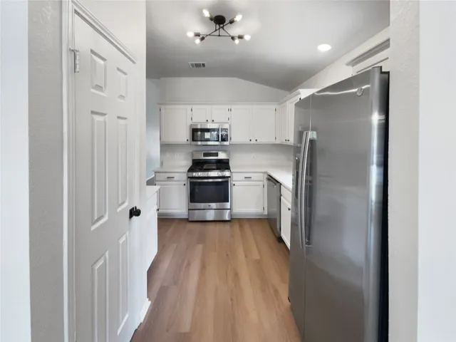 a kitchen with stainless steel appliances a refrigerator and a stove top oven