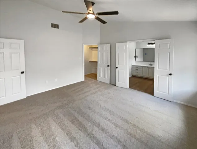 a view of empty room with cabinet and ceiling fan