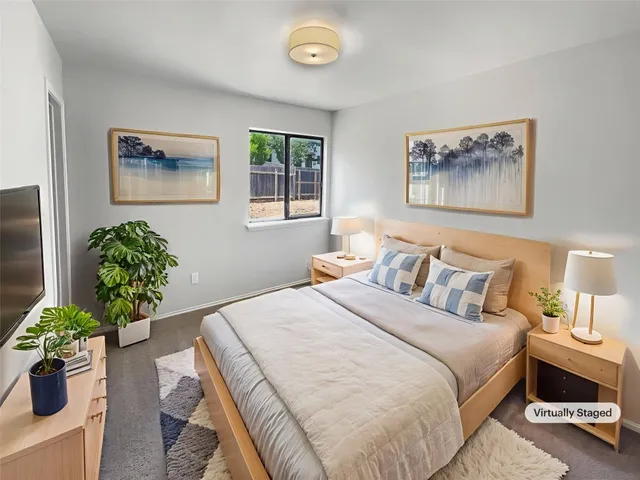 a bedroom with a bed and a painting on the wall