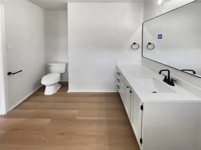 a bathroom with a double vanity sink and a toilet
