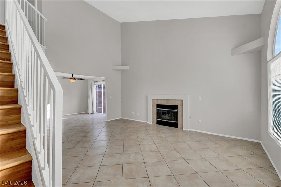 10148 Tree Bark Street Las Vegas, NV 89183 - Photo 3 of 37 A spacious living area with soaring ceilings and a cozy fireplace creates a comfortable ambiance.