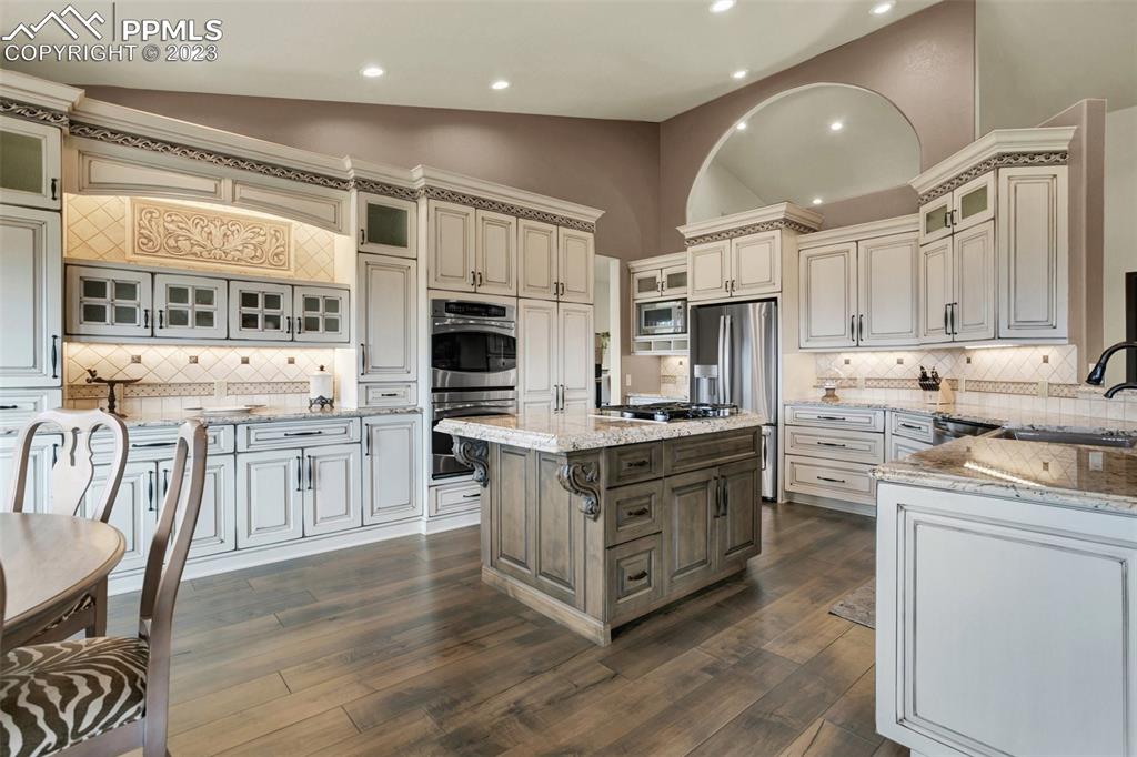 14525 Sterling Road Colorado Springs, CO 80921 - Photo 15 of 46 a kitchen with stainless steel appliances kitchen island granite countertop a stove a sink and a refrigerator