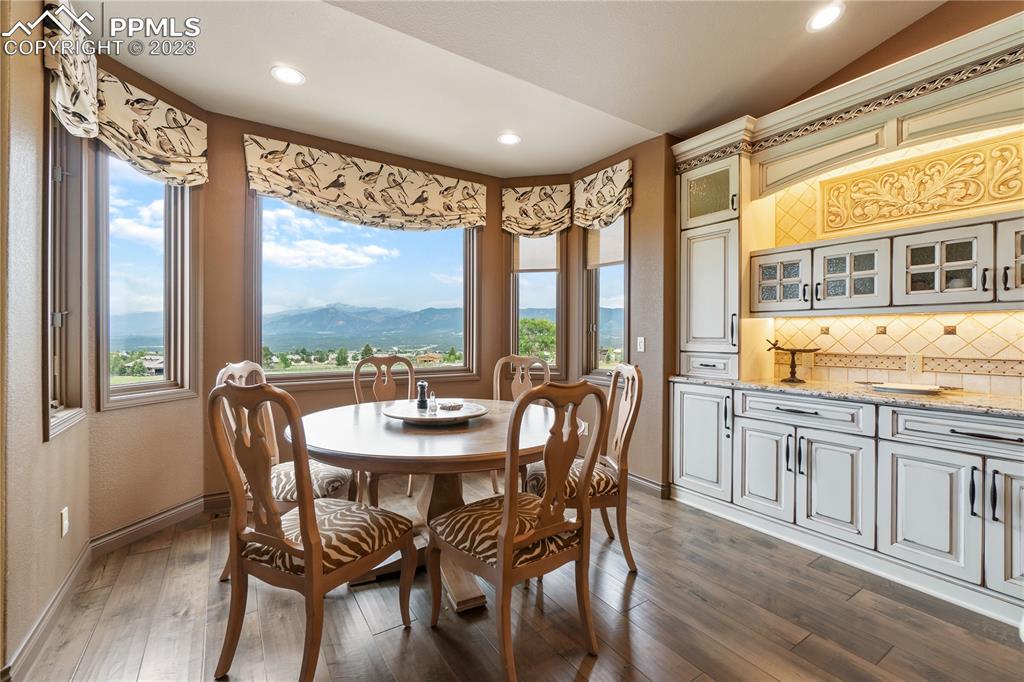 14525 Sterling Road Colorado Springs, CO 80921 - Photo 17 of 46 a view of a dining room with furniture large windows and wooden floor