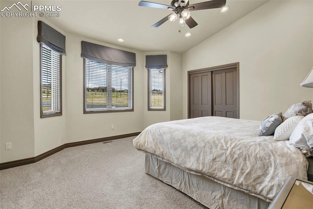 14525 Sterling Road Colorado Springs, CO 80921 - Photo 31 of 46 a bedroom with a large bed and a chandelier