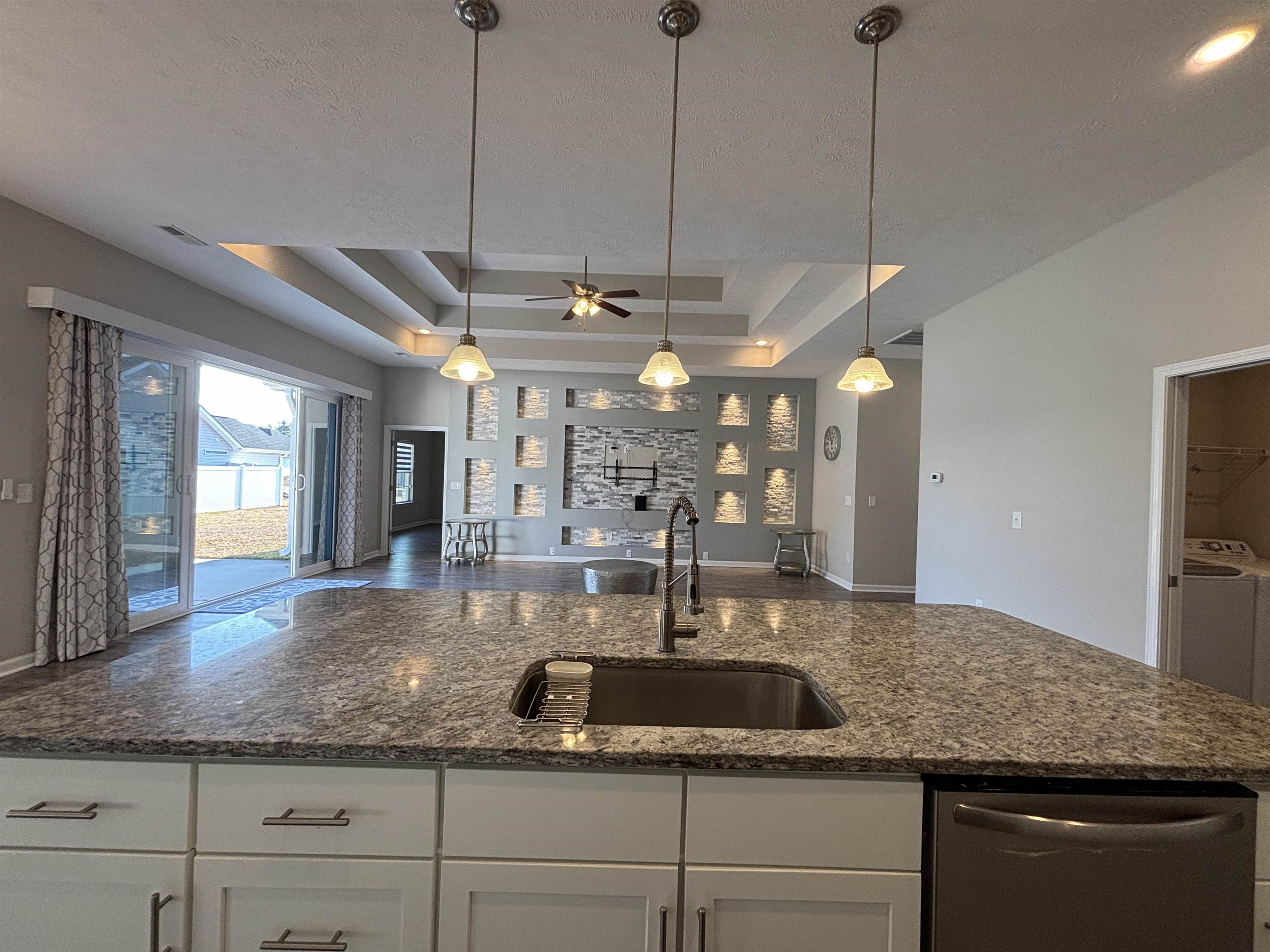 227 Leste Road Myrtle Beach, SC 29588 - Photo 32 of 33 Kitchen featuring white cabinetry, stainless steel dishwasher, dark stone counters, open floor plan, and a textured ceiling