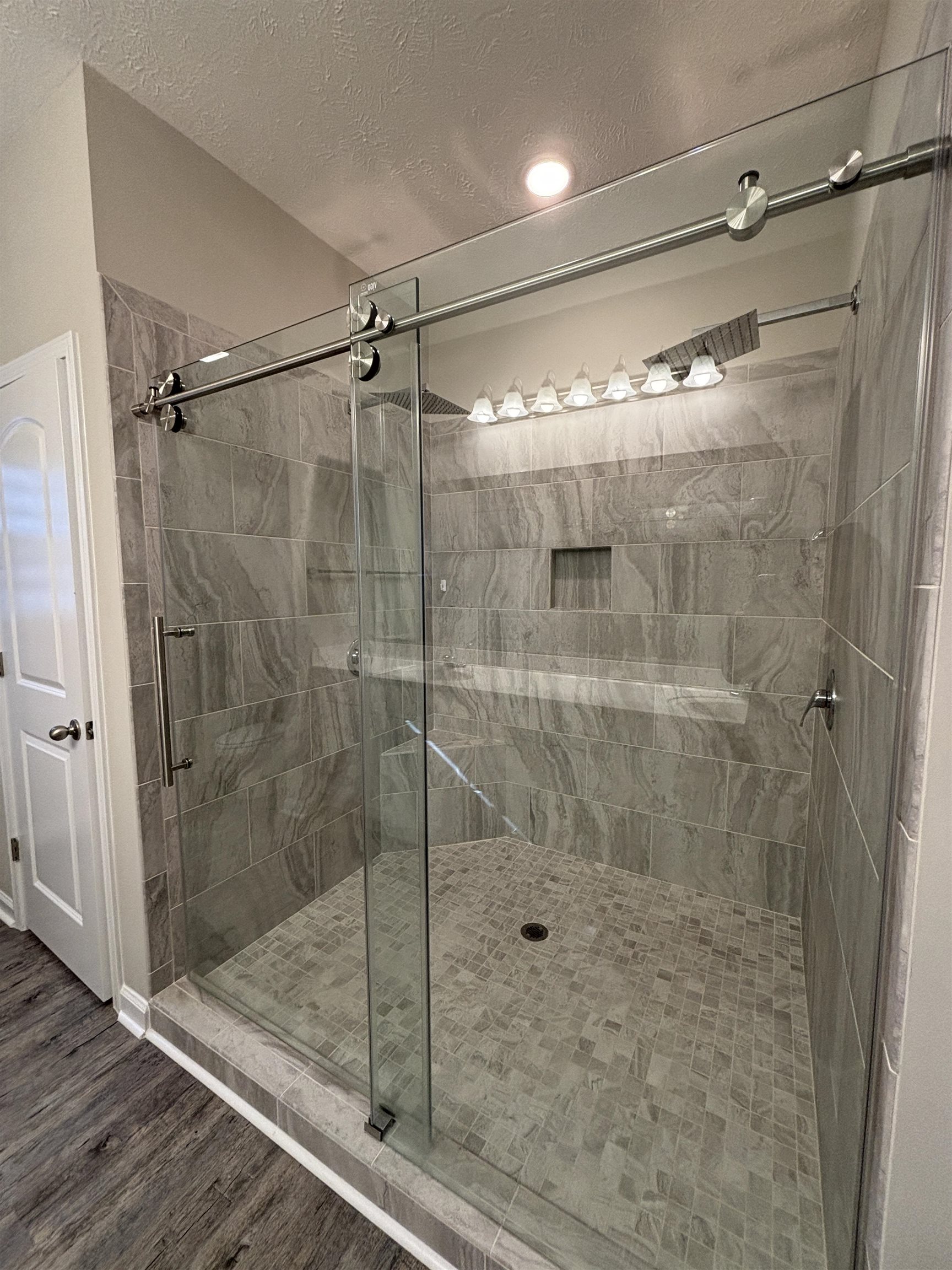 227 Leste Road Myrtle Beach, SC 29588 - Photo 12 of 33 Full bathroom featuring a shower stall, a textured ceiling, and wood finished floors