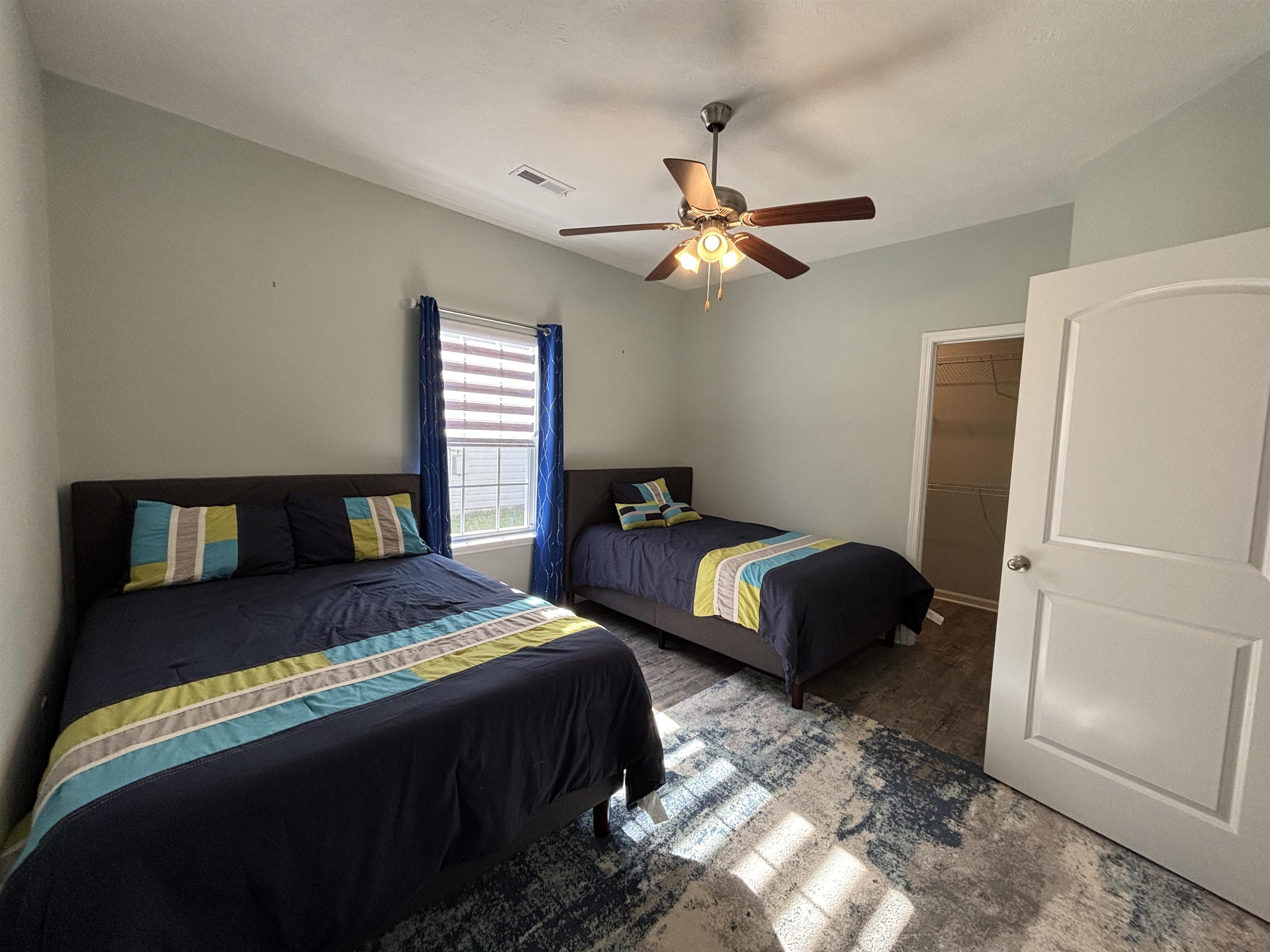 227 Leste Road Myrtle Beach, SC 29588 - Photo 21 of 33 Bedroom with a walk in closet, a ceiling fan, and wood finished floors