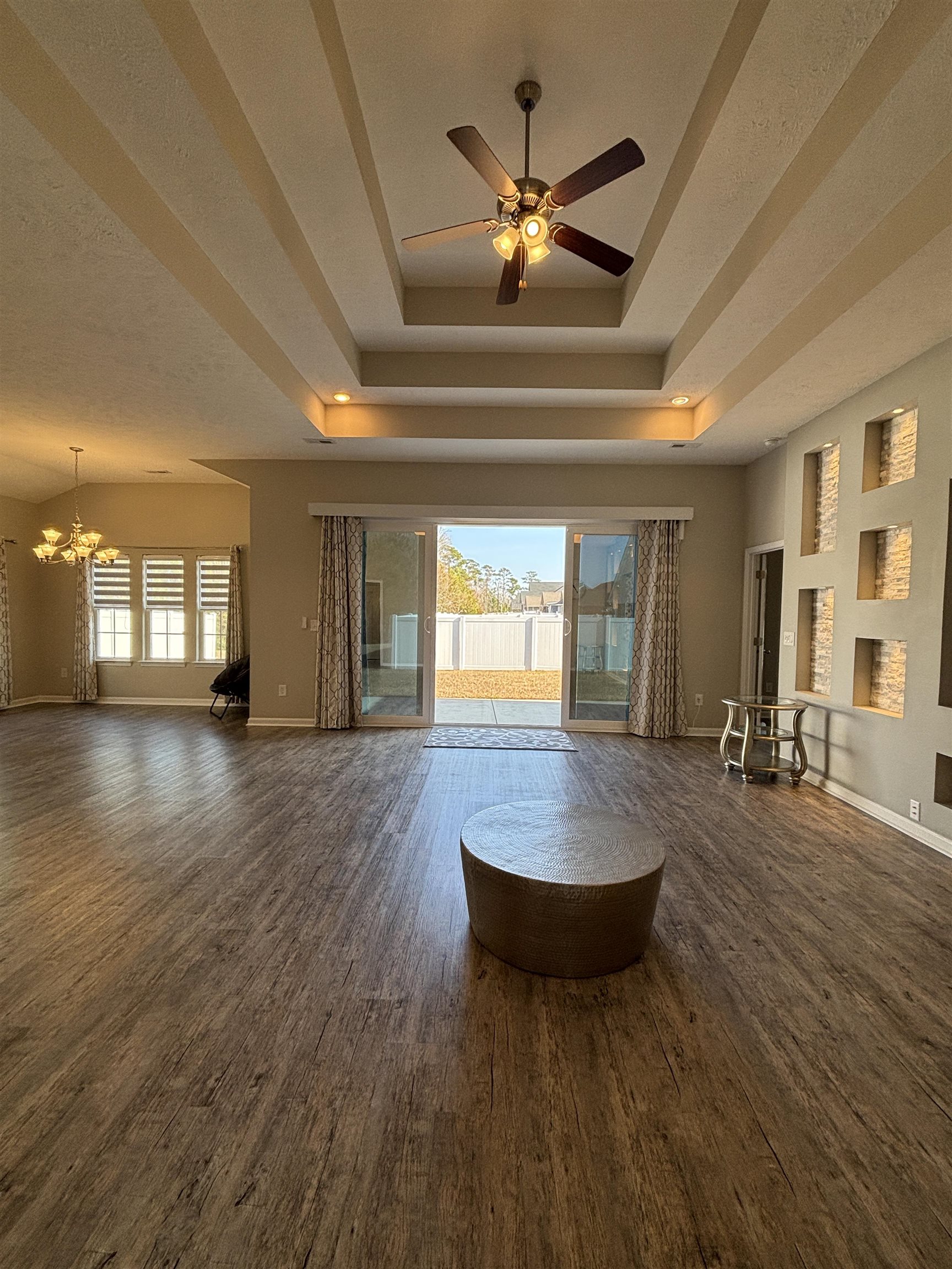 227 Leste Road Myrtle Beach, SC 29588 - Photo 24 of 33 Unfurnished living room featuring a ceiling fan, plenty of natural light, dark wood-style flooring, and a chandelier