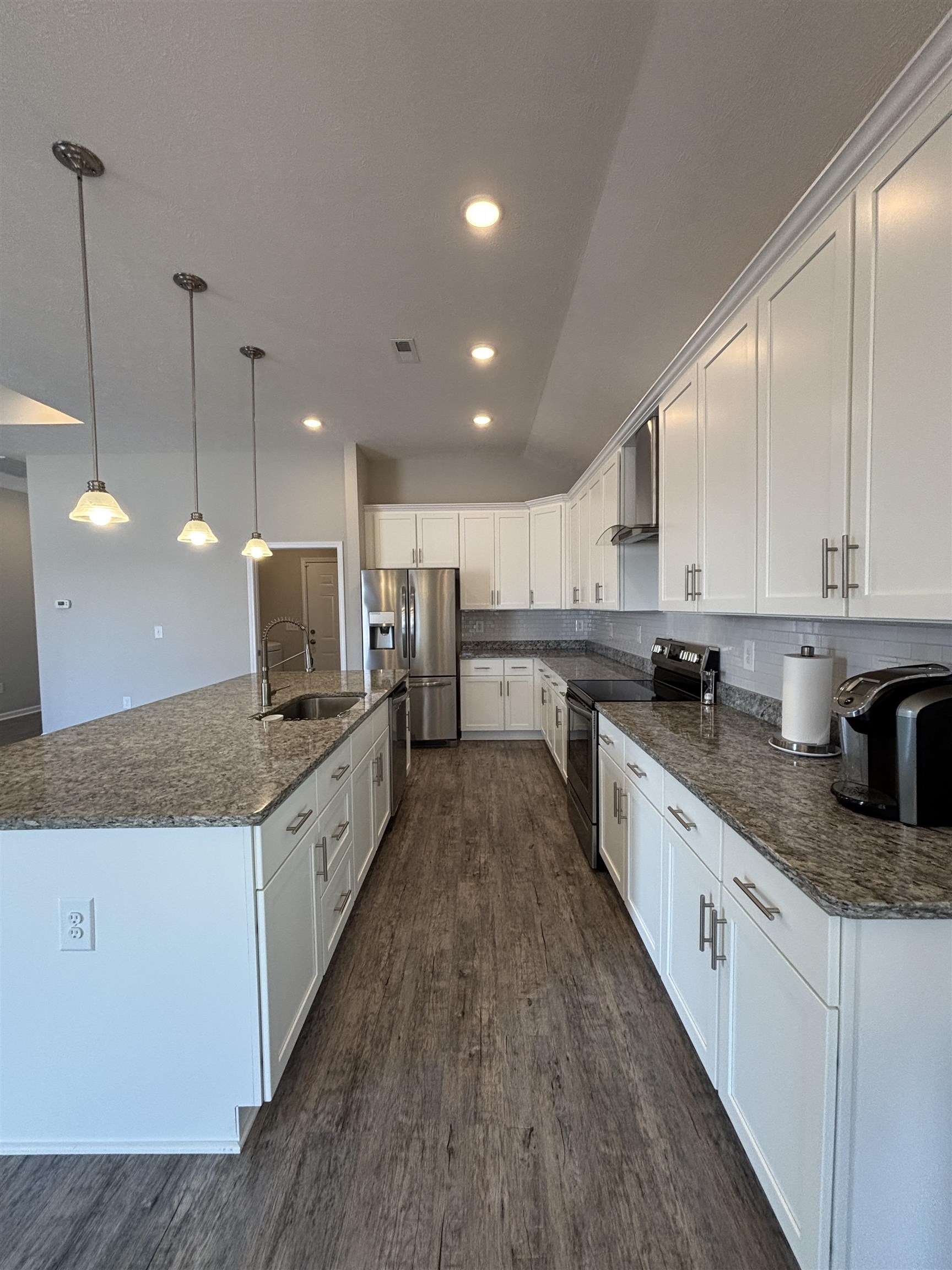 227 Leste Road Myrtle Beach, SC 29588 - Photo 8 of 33 Kitchen with appliances with stainless steel finishes, a center island with sink, decorative light fixtures, white cabinetry, and dark stone counters