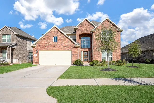 a front view of a house with a yard and garage