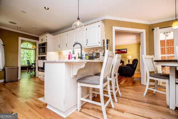 a kitchen with stainless steel appliances white cabinets and a stove top oven