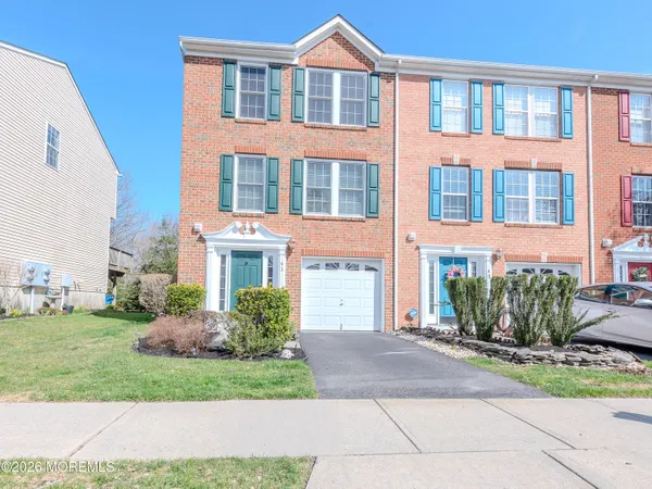 front view of a brick house with a yard