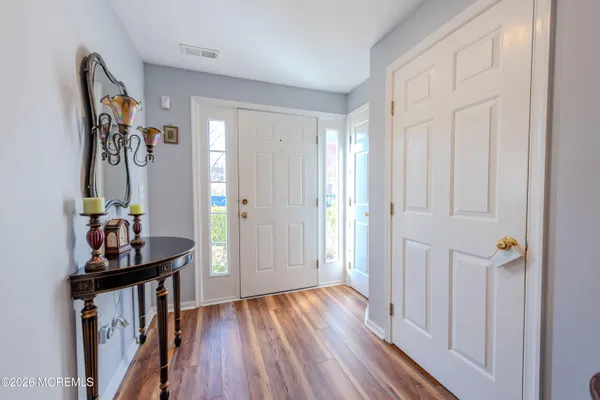a view of a hallway with wooden floor and closet