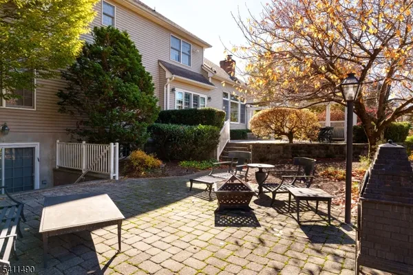 a view of a patio with table and chairs potted plants and a large tree