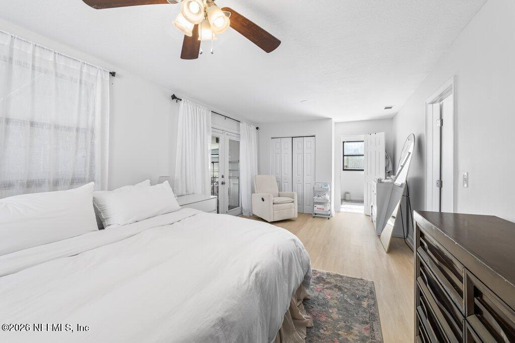 4145 Springwood Road Jacksonville, FL 32207 - Photo 16 of 33 a spacious bedroom with a bed a dresser and wooden floor