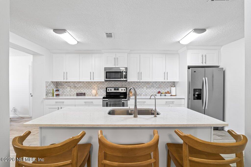 4145 Springwood Road Jacksonville, FL 32207 - Photo 3 of 33 a kitchen with stainless steel appliances granite countertop a sink a stove a refrigerator cabinets and chairs