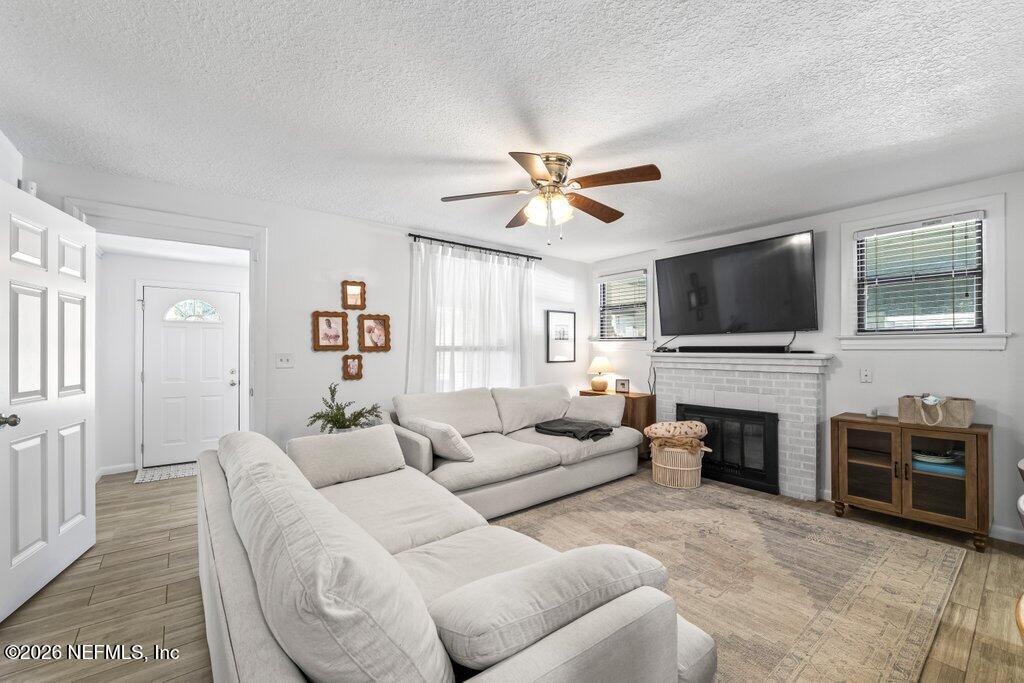 4145 Springwood Road Jacksonville, FL 32207 - Photo 6 of 33 a living room with furniture a fireplace and a flat screen tv