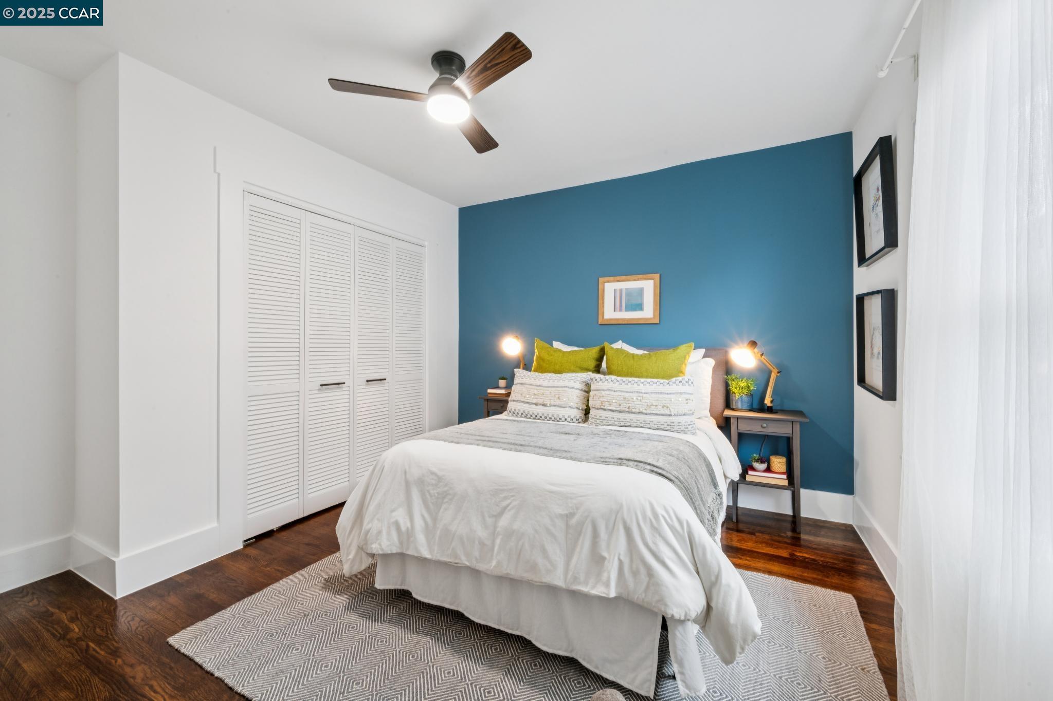 1128 60th Avenue Oakland, CA 94621 - Photo 5 of 7 a bedroom with a bed and wooden floor