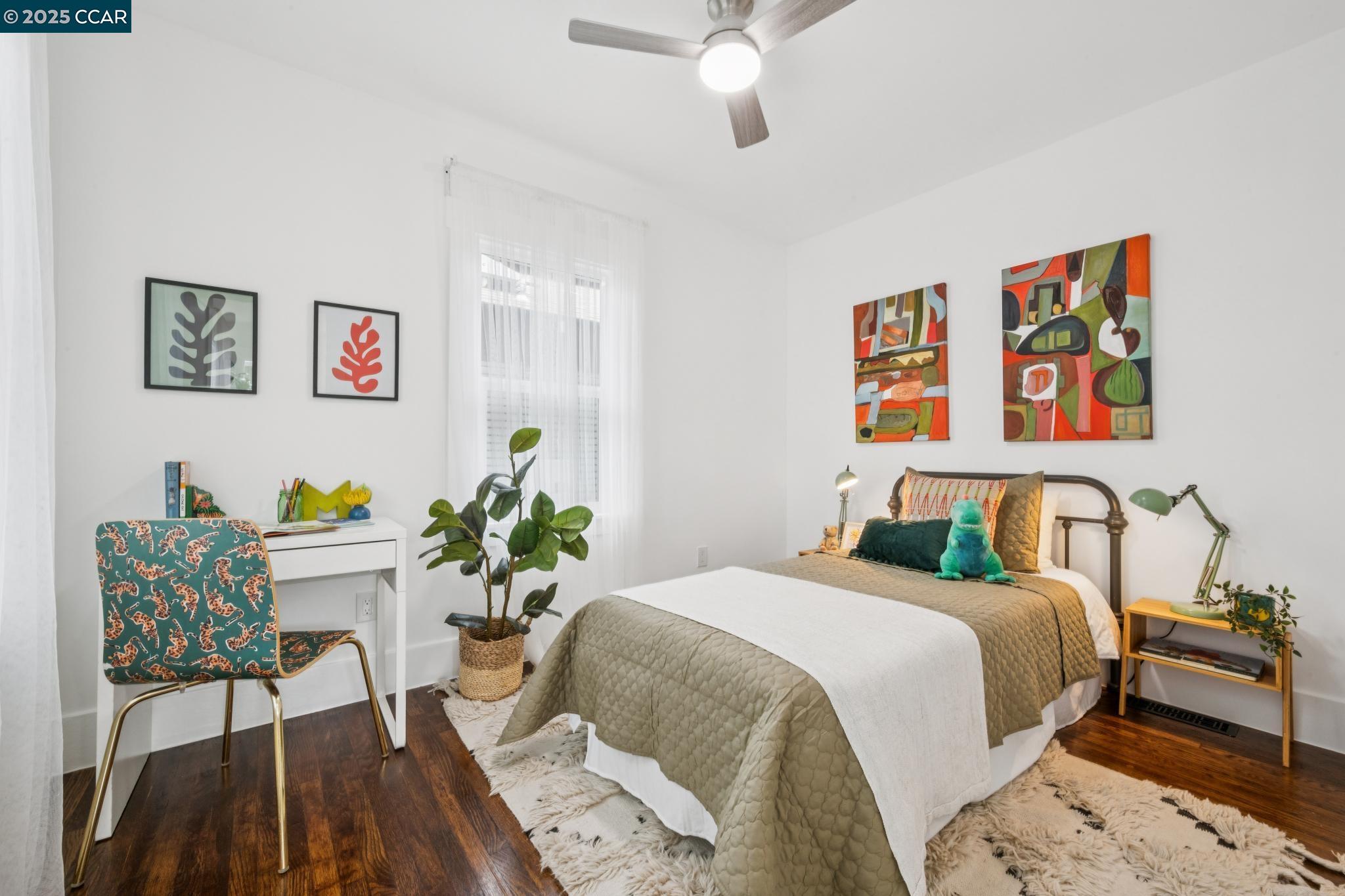 1128 60th Avenue Oakland, CA 94621 - Photo 6 of 7 a bedroom with a bed and a table