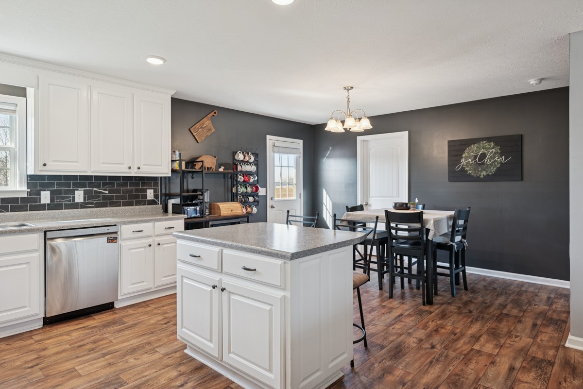 4915 Little Dry Creek Road Pulaski, TN 38478 - Photo 13 of 45 a kitchen with kitchen island granite countertop a dining table chairs and white cabinets