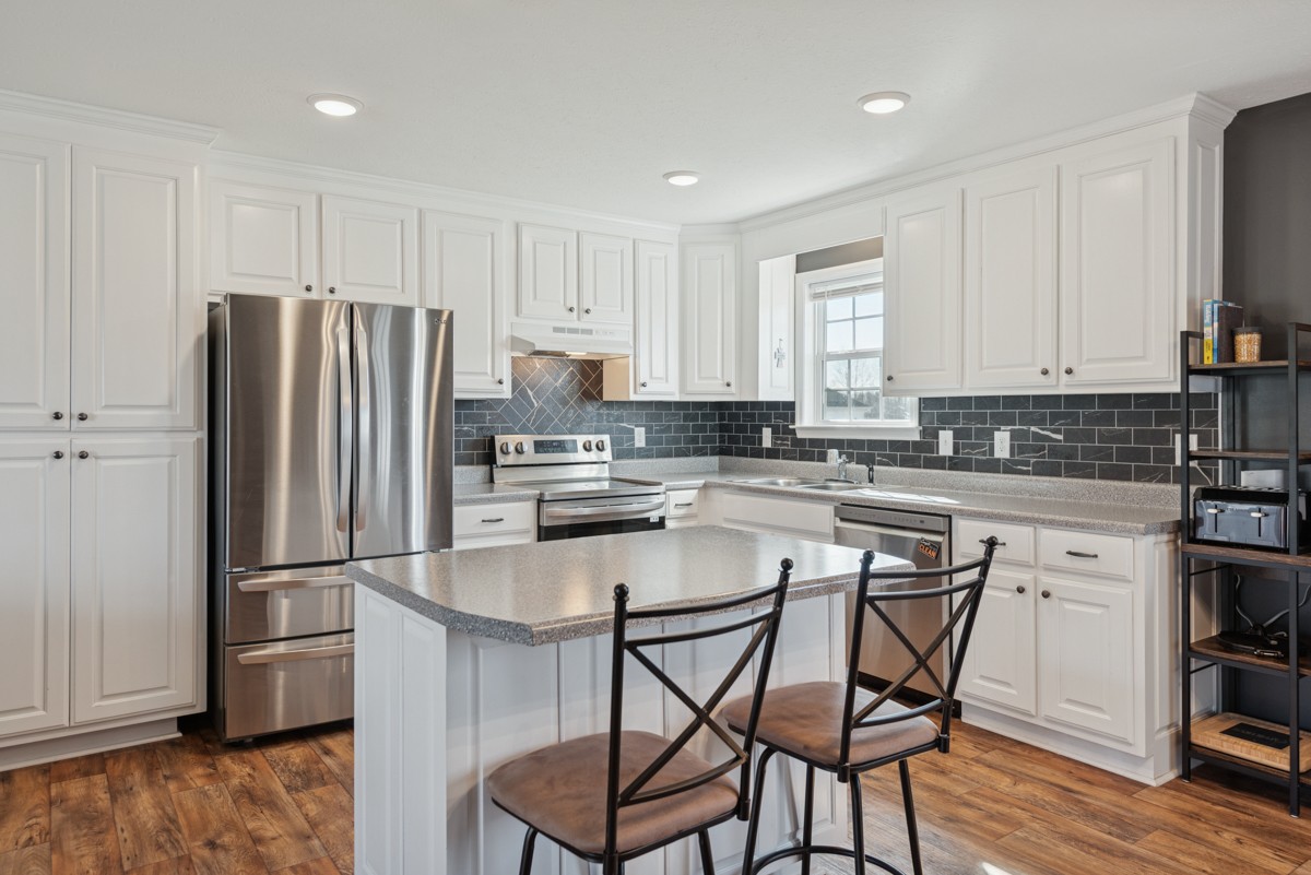 4915 Little Dry Creek Road Pulaski, TN 38478 - Photo 14 of 45 a kitchen with stainless steel appliances granite countertop a refrigerator a stove a sink and white cabinets with wooden floor