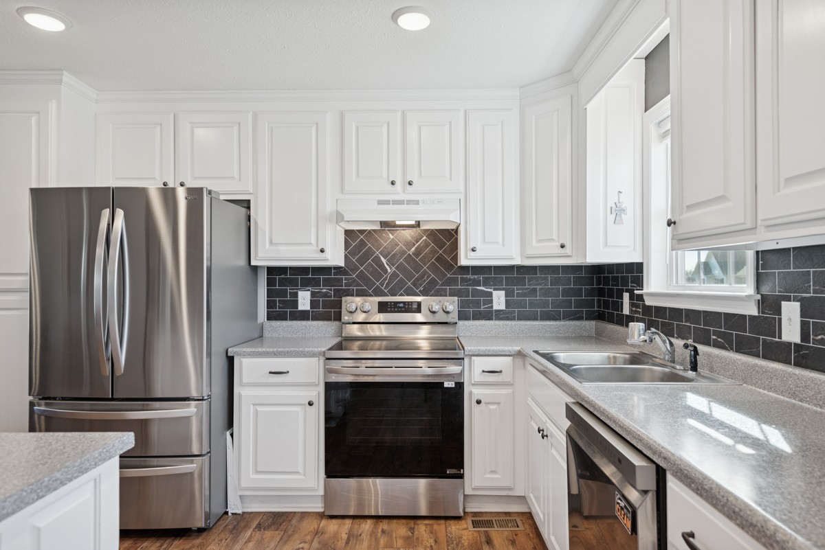 4915 Little Dry Creek Road Pulaski, TN 38478 - Photo 15 of 45 a kitchen with stainless steel appliances granite countertop a stove a refrigerator and a sink