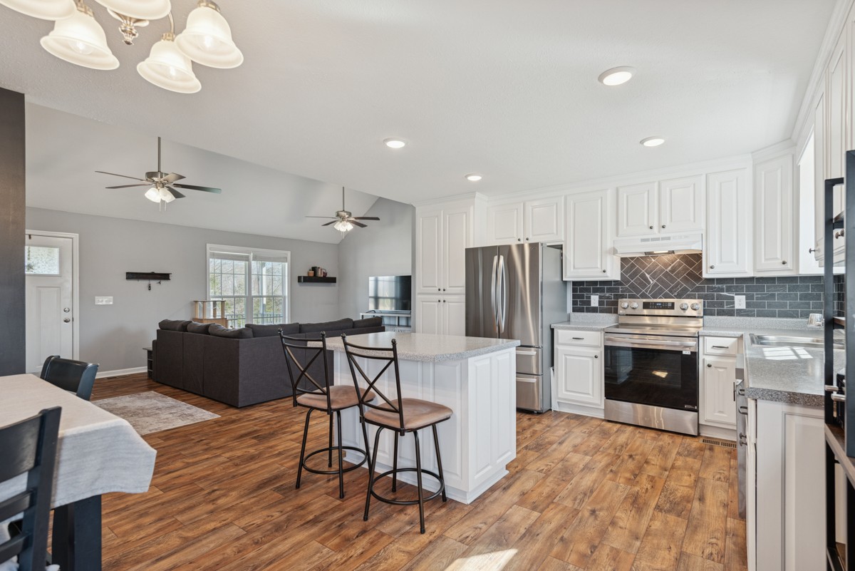 4915 Little Dry Creek Road Pulaski, TN 38478 - Photo 10 of 45 a kitchen with stainless steel appliances granite countertop a refrigerator a stove a sink a dining table and chairs with wooden floor