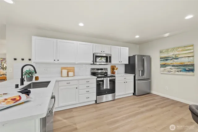a kitchen with stainless steel appliances granite countertop a refrigerator sink and stove