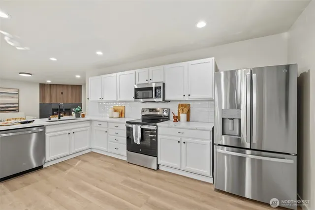 a kitchen with cabinets stainless steel appliances and a counter space