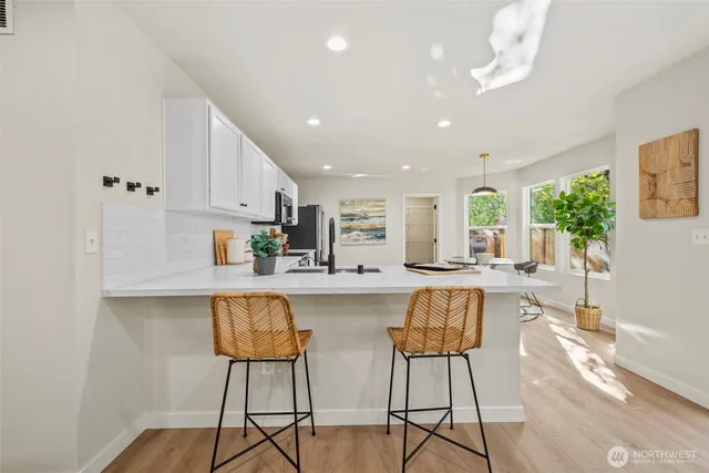 a kitchen with stainless steel appliances a table and chairs in it