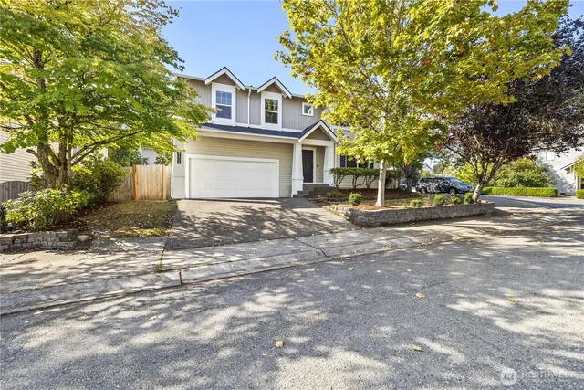 a front view of a house with a tree