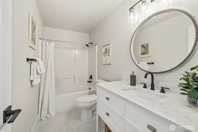 a bathroom with a granite countertop sink mirror vanity and toilet