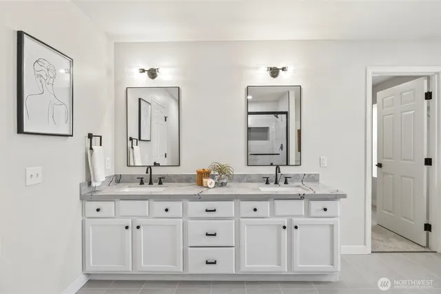 a bathroom with double sink and a mirror