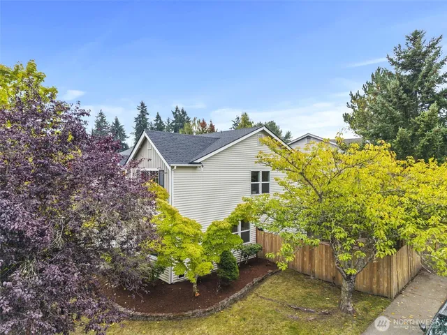 a view of a house with a big yard and large trees