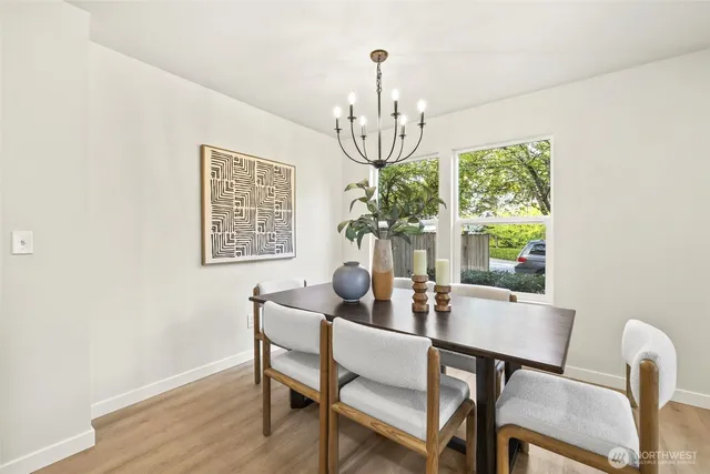 a dining room with furniture a chandelier and wooden floor