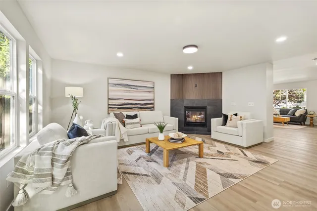 a living room with fireplace furniture and a large window