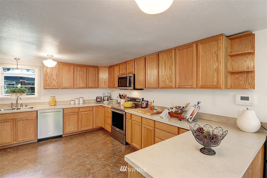 24217 4th Place West Bothell, WA 98021 - Photo 4 of 19 a kitchen with stainless steel appliances granite countertop a sink dishwasher stove top oven and cabinets