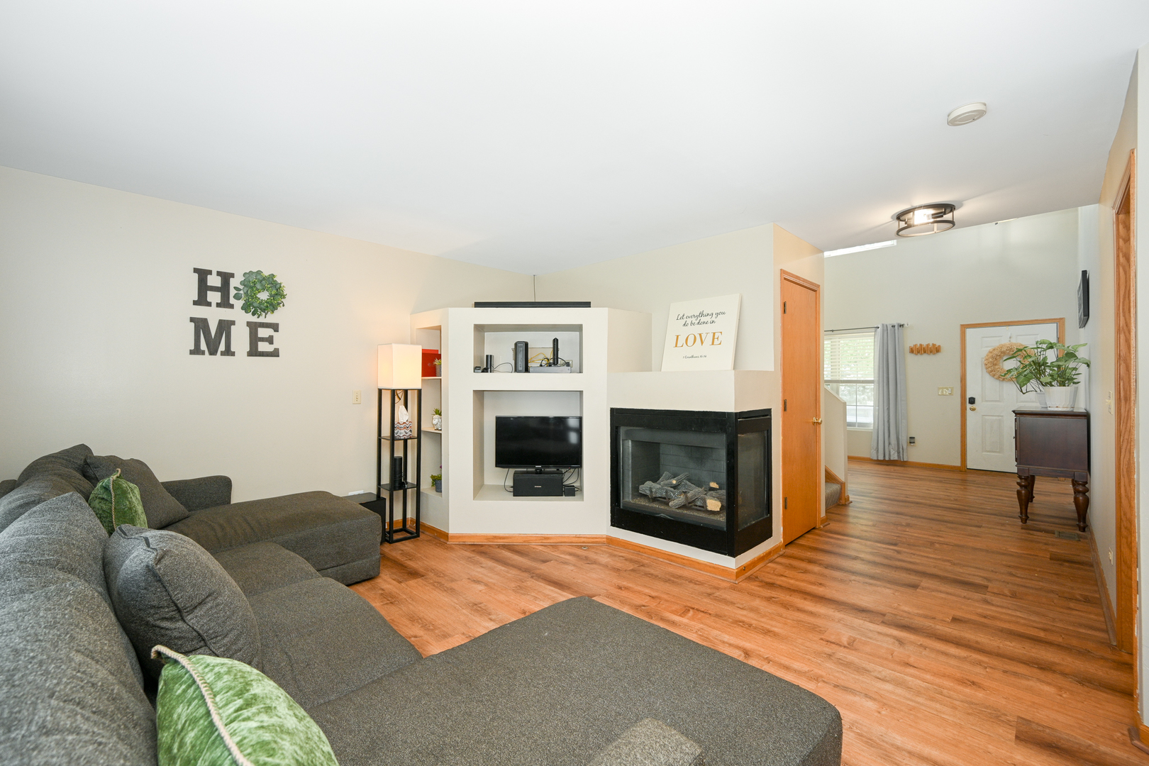 5805 Emerald Pointe Drive Plainfield, IL 60586 - Photo 7 of 25 a living room with furniture a fireplace and a flat screen tv