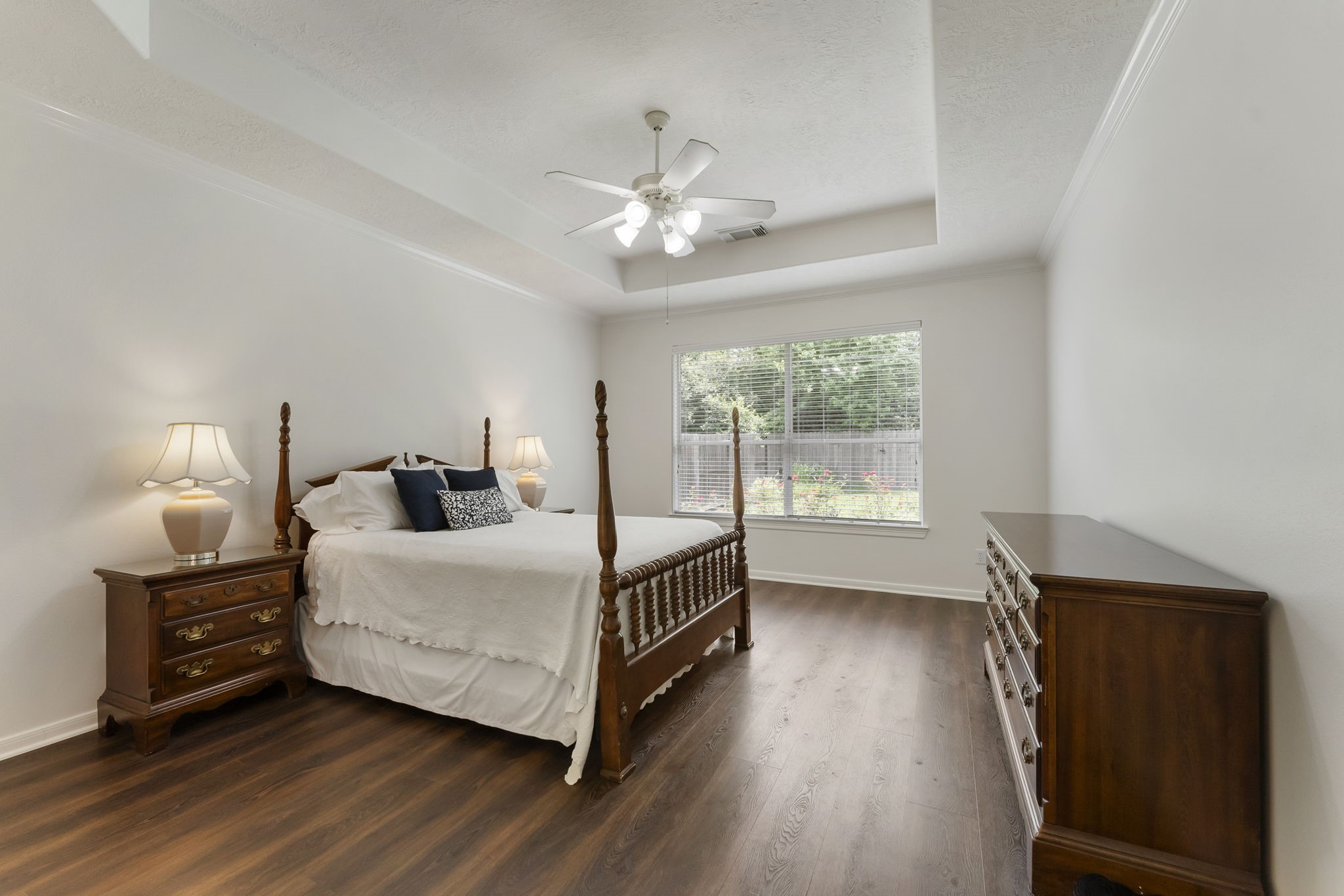 6643 Knollbridge Lane Spring, TX 77379 - Photo 16 of 50 Primary bedroom quietly tucked away on the first floor boasts a trey ceiling with ceiling fan and a large window overlooking your lush backyard.