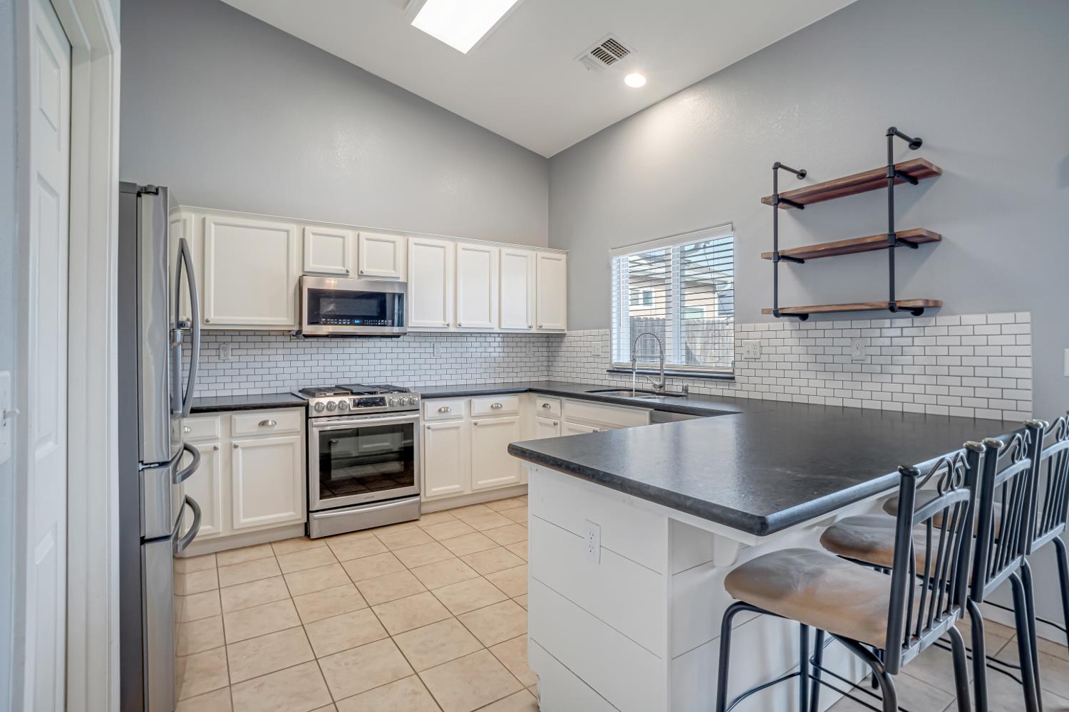 3062 North Filbert Avenue Fresno, CA 93727 - Photo 4 of 41 a kitchen with kitchen island a stove a sink and a refrigerator