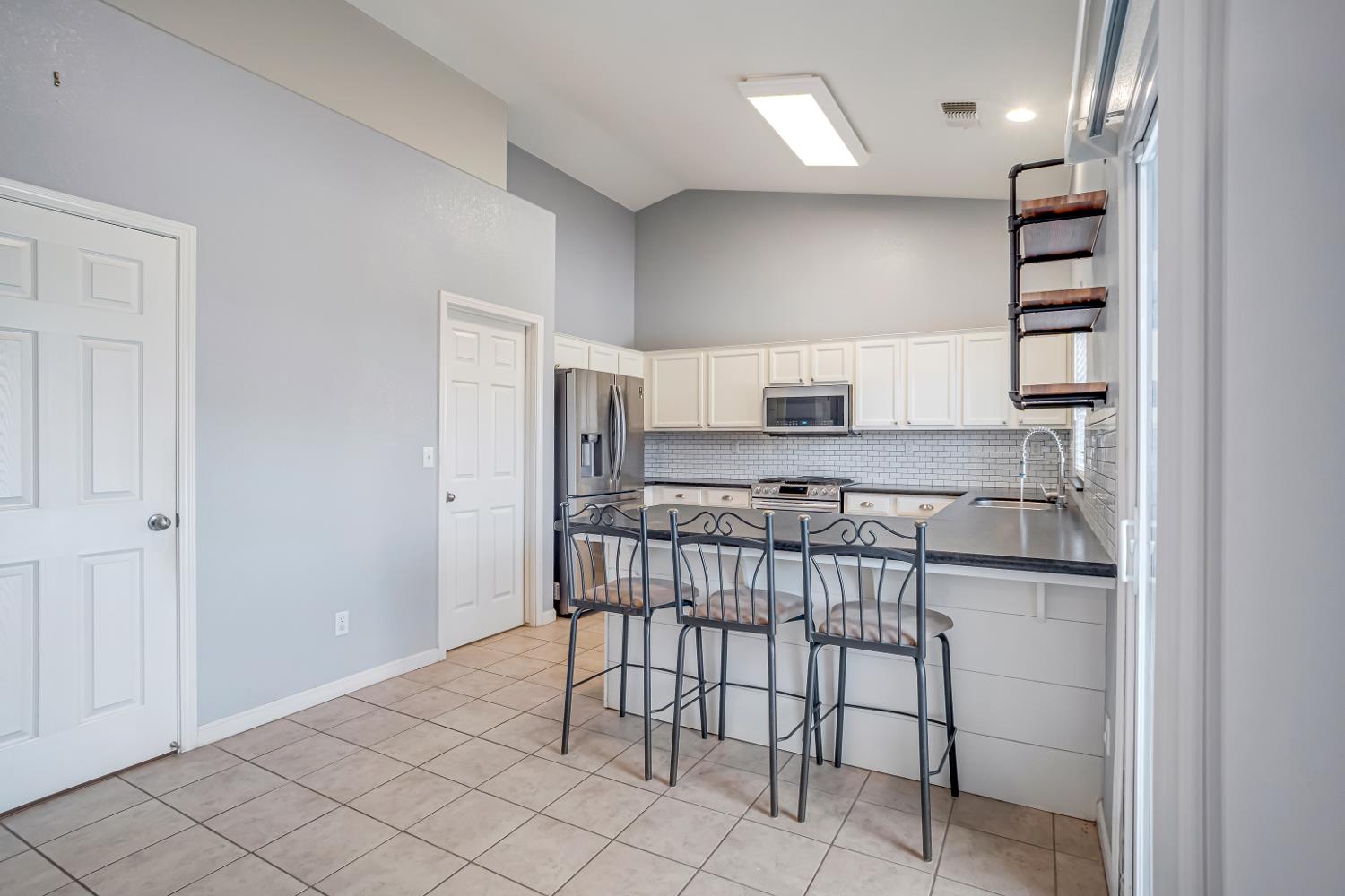 3062 North Filbert Avenue Fresno, CA 93727 - Photo 7 of 41 a kitchen with stainless steel appliances kitchen island granite countertop a refrigerator and a stove top oven