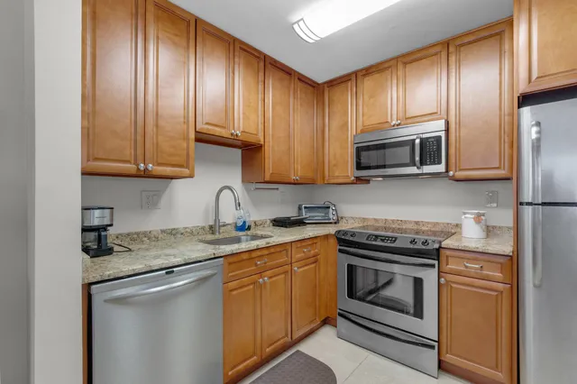 a kitchen with cabinets stainless steel appliances and a sink