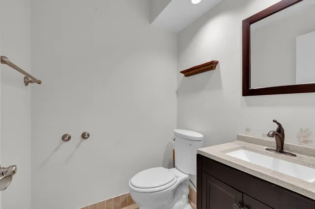 a bathroom with a granite countertop sink a toilet and a mirror
